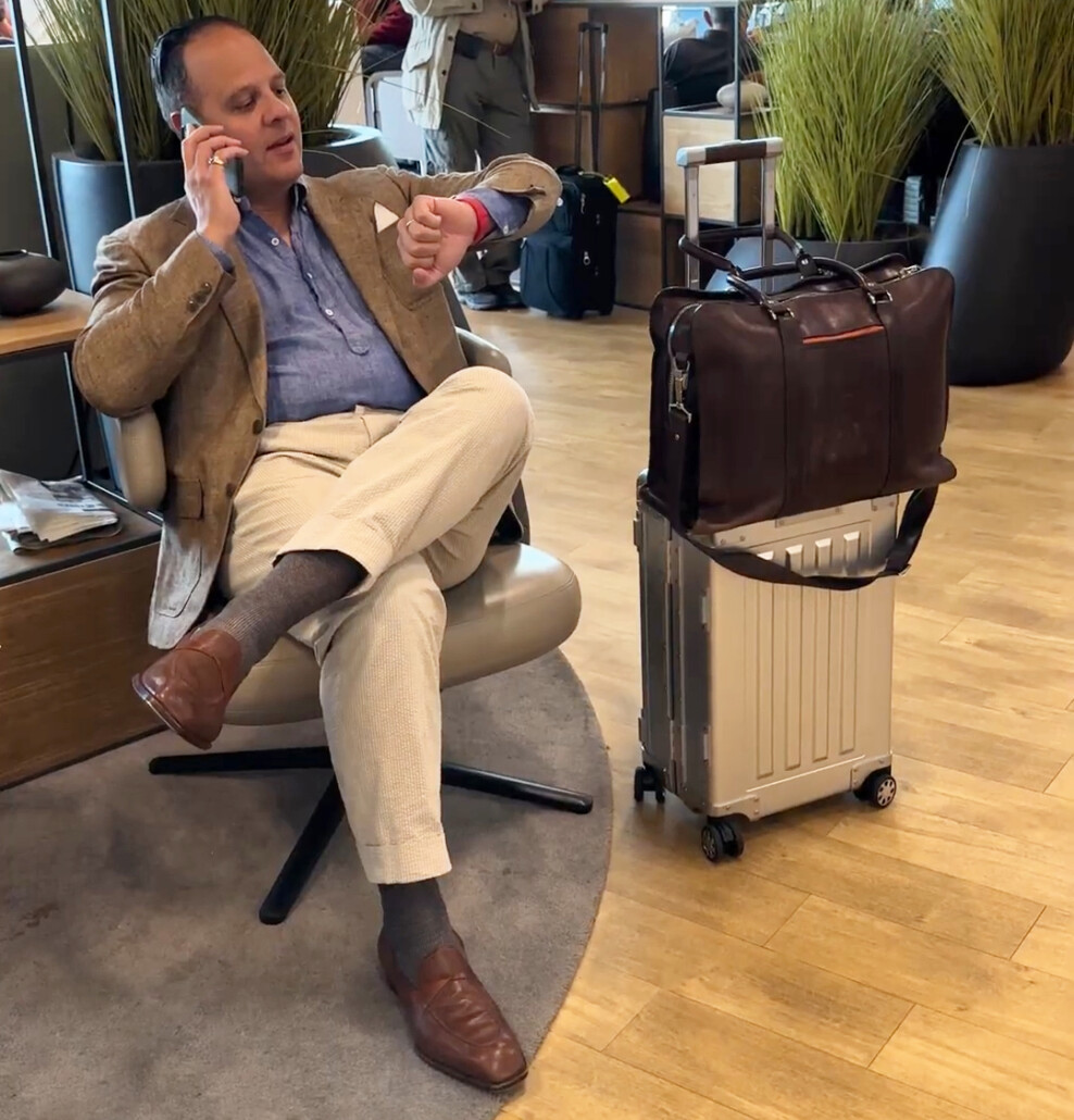 Raphael In Airport Lounge With Sterling Pacific Raphael talks on the phone in an airport lounge with his Sterling Pacific bag beside him.