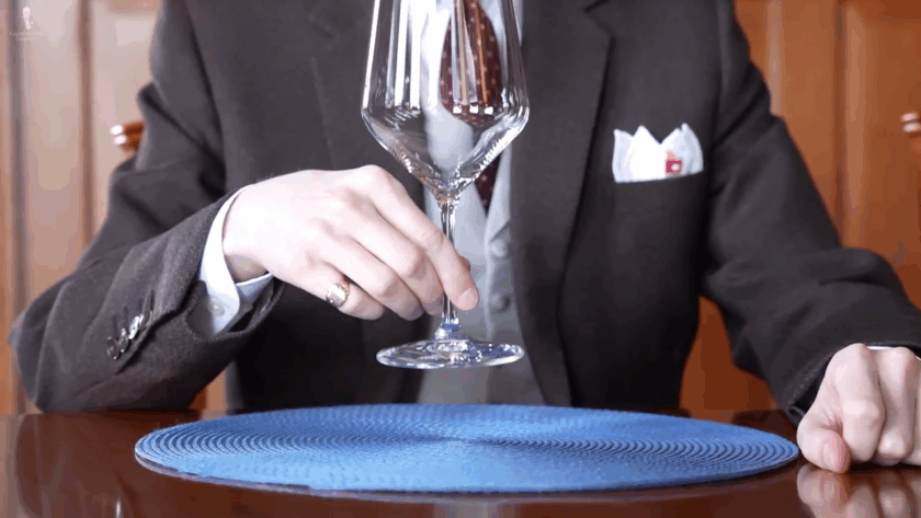 Hand holding a beer goblet glass by the stem