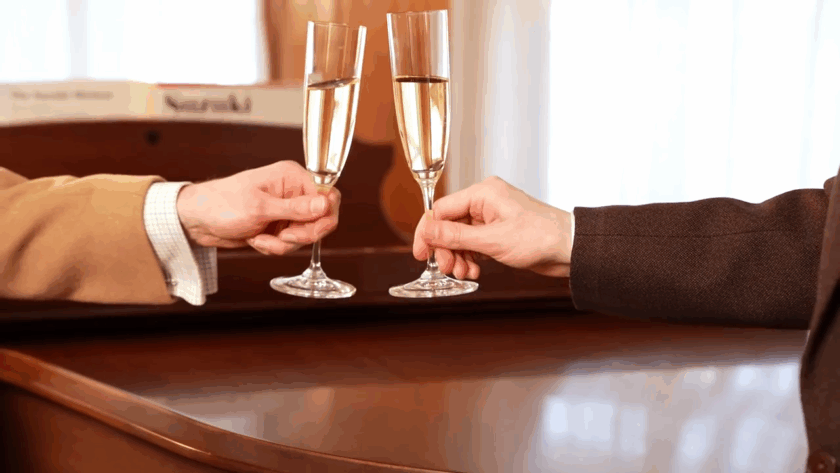lightly gripping champagne flutes by the stem for a proper toast
