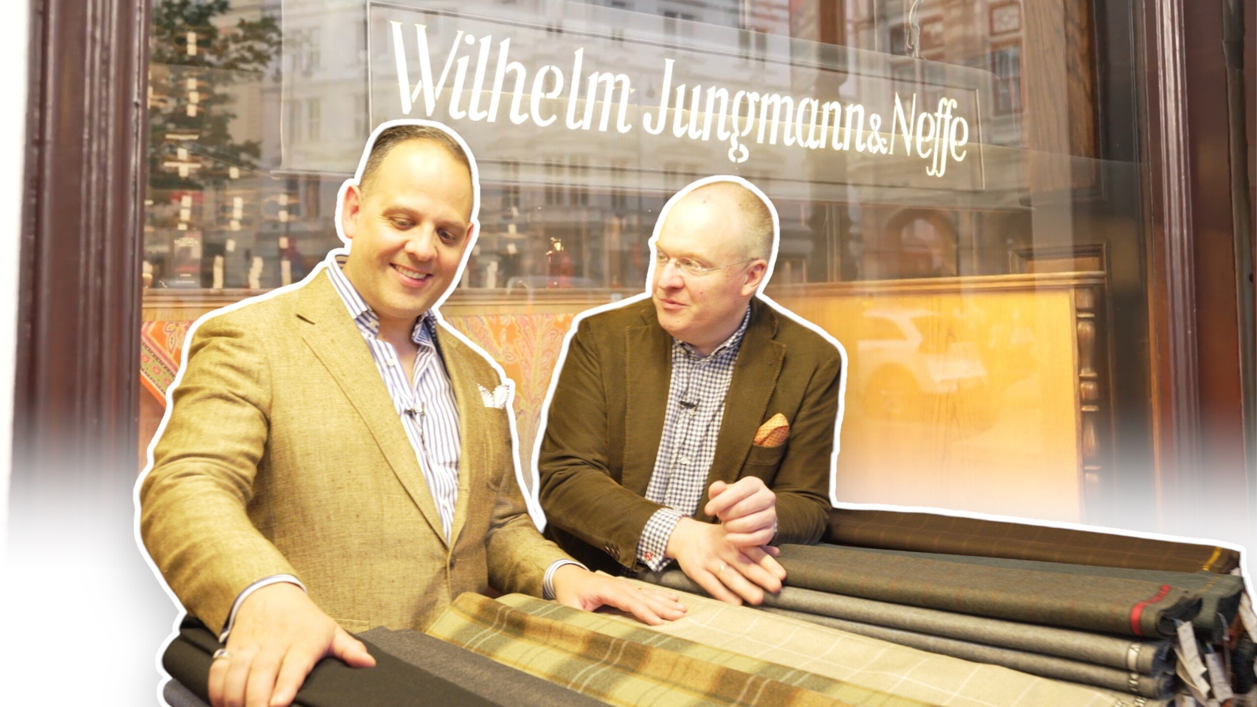 neffe new banner 3840x2160 1 scaled Two men pose with fabrics in front of a store sign