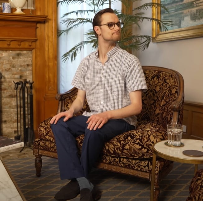 Sitting Ankles Crossed Man sitting with legs crossed at the ankles on an armchair