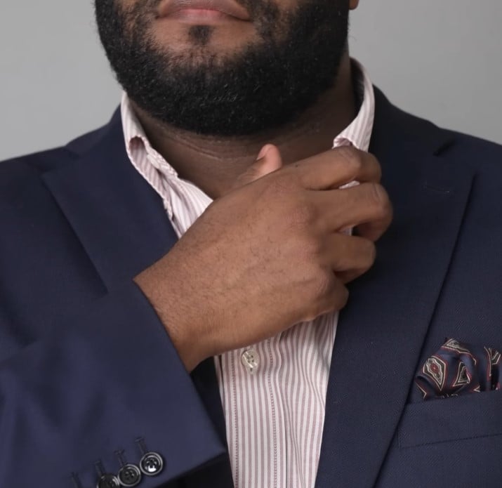 Gentleman Pink Striped Dress Shirt A man in a navy blazer adjusting the collar of his salmon pink and white striped dress shirt.