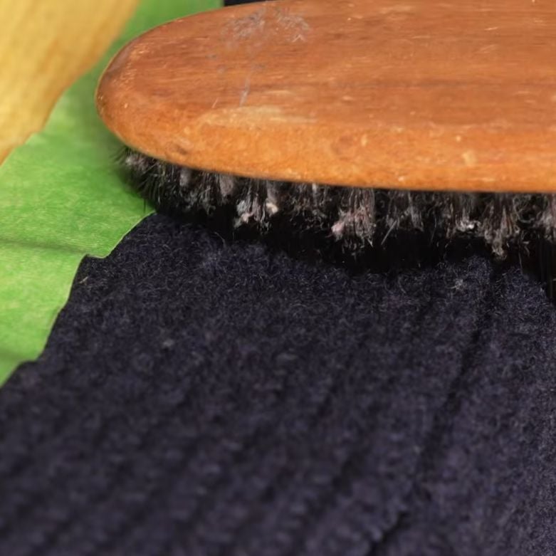 Pumice stone used to remove pilling from a wool sweater during a garment care test.