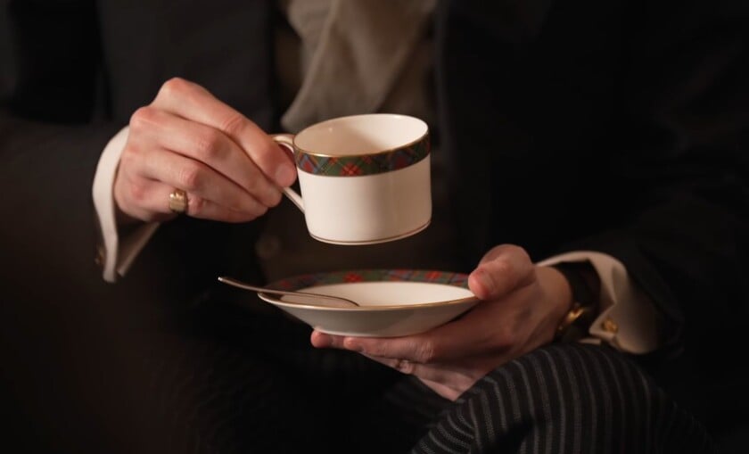 Person holding a teacup and saucer correctly while seated