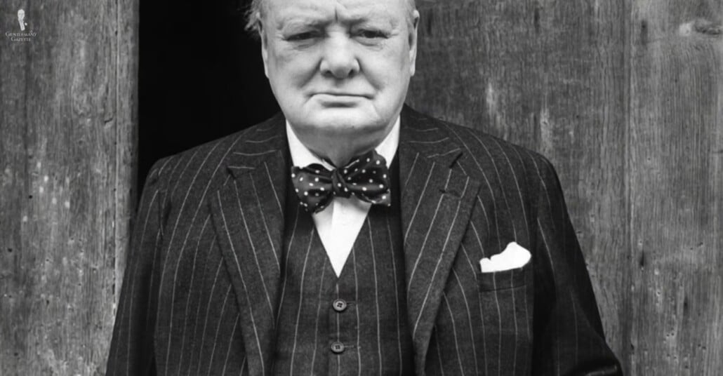 Winston Churchill wearing a three-piece suit with a spotted bow tie.