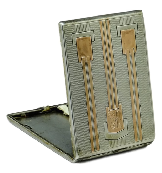 Cigarette Case An open, vintage metal cigarette case featuring a two-toned silver and gold geometric Art Deco design on its outer cover