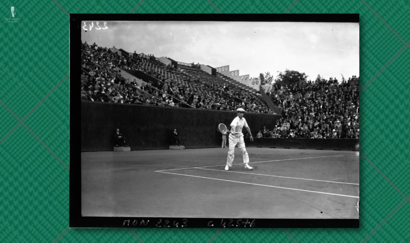 1920s Tennis Players White Flannels Crowd Black-and-white photograph of a male tennis player from the 1920s in white flannel trousers and long-sleeved shirt, with a packed grandstand in the background