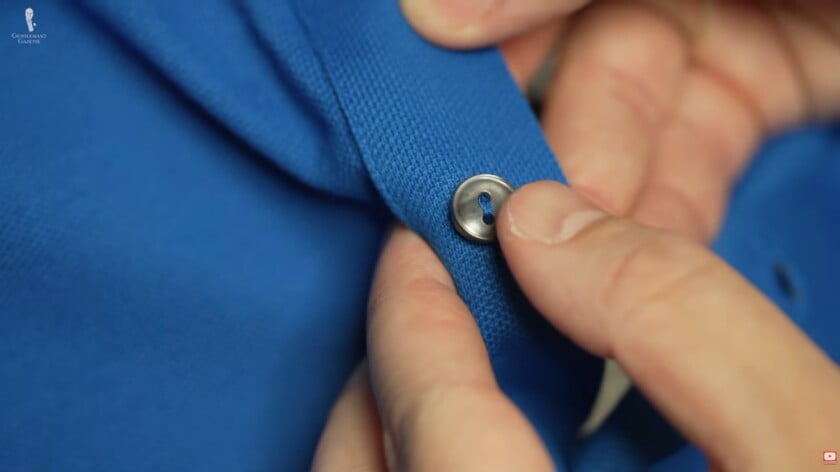 polo shirt buttons Rafael inspects the buttons of the polo shirt.