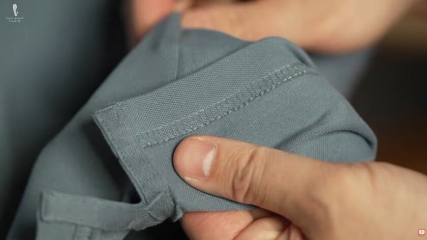 polo stitching close up Rafael inspects the stitching of a polo shirt