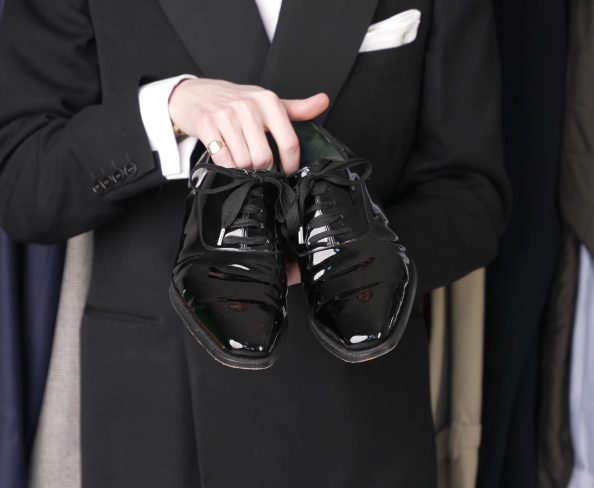 Black Patent Leather Whole Cut Evening Shoes Jack Collins holding a pair of black patent leather whole-cut evening shoes with black laces