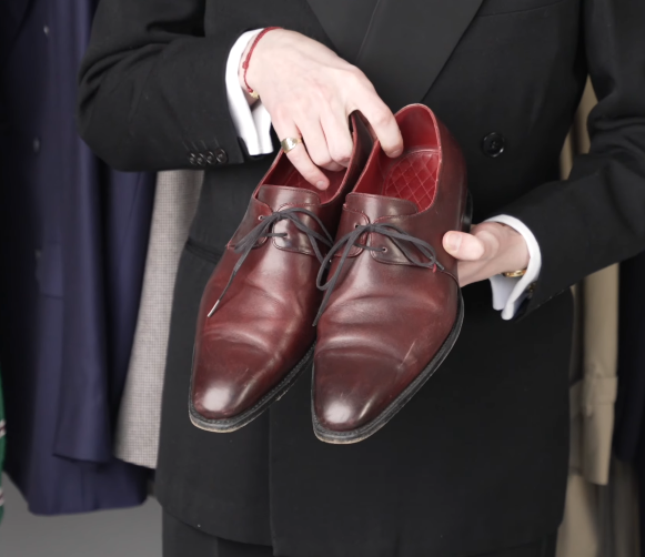 Burgundy Cordovan Plain Toe Derby Shoes Jack Collins holding a pair of burgundy cordovan plain-toe derby shoes with a quilted red lining
