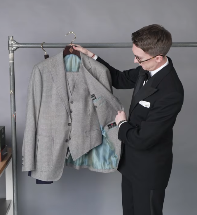 Gray Puppytooth Three Piece Suit Patch Pockets Jack Collins holding open a gray puppytooth three-piece suit to show the light blue lining, with patch pockets visible on the jacket