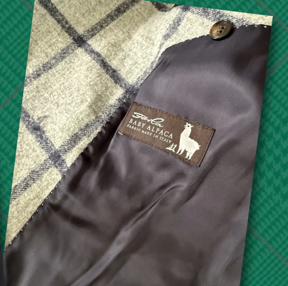 Baby Alpaca Windowpane Jacket Label Cream and gray windowpane baby alpaca jacket cloth folded back to show the satin lining and woven "Baby Alpaca, fabric made in Italy" label