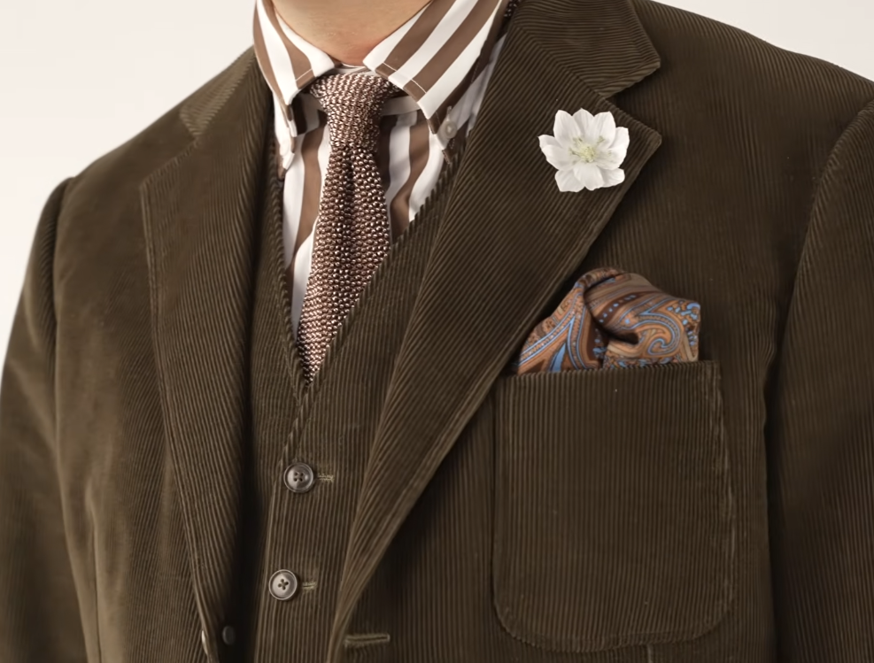 Corduroy Olive Three Piece Suit Olive corduroy three-piece suit showing vertical wales on the lapel and pocket, worn with a brown striped shirt, knit tie, and paisley pocket square