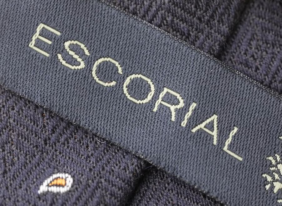 Escorial Fabric Label Woven ESCORIAL label on navy herringbone fabric with the Escorial trademark emblem