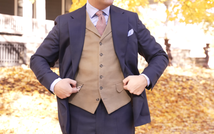 Moleskin Tan Waistcoat Navy Suit Tan moleskin waistcoat worn as an odd waistcoat under an open navy suit jacket, showing the soft matte suede-like surface