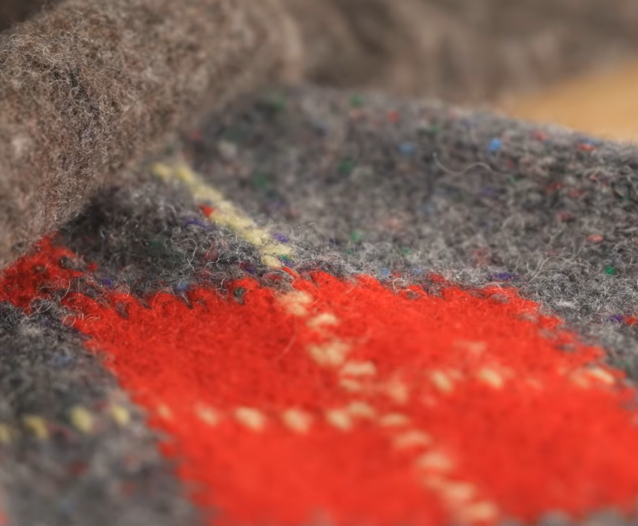 Shetland Wool Brushed Argyle Close Up Close-up of heathered gray Shetland wool with a red and yellow argyle pattern